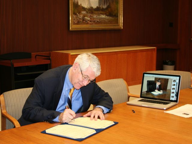 Berkeley Chancellor Robert Birgeneau signs an agreement